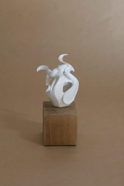 sculpture céramique blanche représentant une femme avec la méthapore d'un instrument de musique. Elles t posée sur un plot en bois massif. L'artiste est la sculptrice Julie Espiau